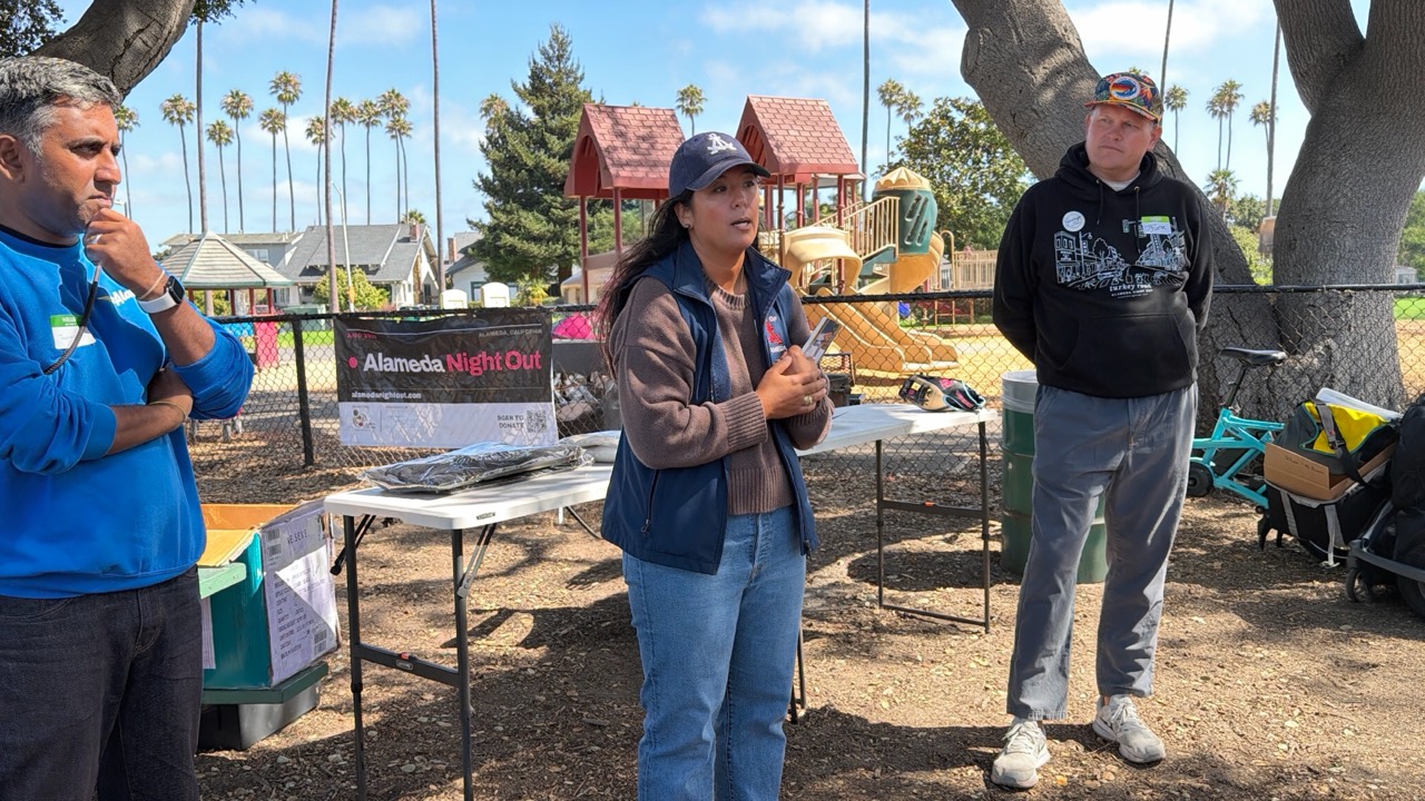 Thushan Amarasiriwardena, Malia Vella and Tyler Savage in conversation with neighbors at Washington Park